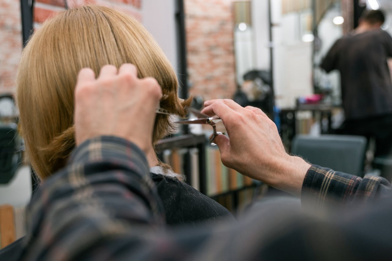 Coiffeur à Bordeaux en train de couper les cheveux d'un client